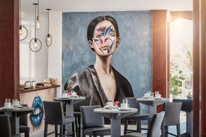 uma pintura num restaurante com mesas e cadeiras em Rox Hotel em Jericoacoara