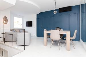 a dining room with blue walls and a table and chairs at Neingam in Cannes