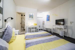 1 Schlafzimmer mit 2 Betten, einem Schreibtisch und einem TV in der Unterkunft Hotel Tusculum in Marburg an der Lahn