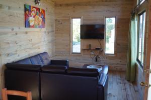 a living room with a couch and a flat screen tv at Rustico Pucon in Pucón