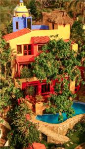 un bâtiment avec une piscine en face d'une maison dans l'établissement Quinta del Encanto, à La Cruz de Huanacaxtle