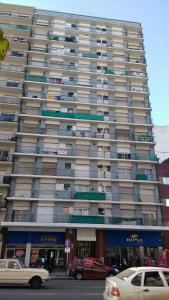 un gran edificio con coches estacionados frente a él en av. Colón Apartamento en Mar del Plata