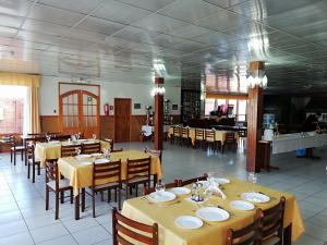 a restaurant with tables and chairs with yellow tablecloths at Agostini Hotel in Puerto Natales