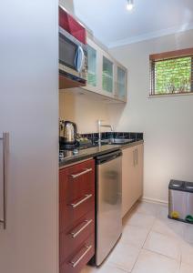 a kitchen with a sink and a dishwasher at Kauri Motel on Riccarton in Christchurch