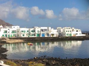 un grupo de casas blancas en el agua en Ocean Sunshine, en Orzola