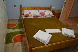 a wooden bed with two pillows and towels on it at Αpartment at the entrance of the city Dimitropoulos in Aigio