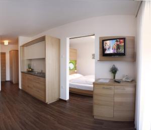 ein Schlafzimmer mit einem Bett und einem TV an der Wand in der Unterkunft Residence Aqualis in Marling
