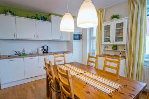 eine Küche und ein Esszimmer mit einem Holztisch und Stühlen in der Unterkunft K2 Aparthotel Klínovec Views - Mezonet Apt in Loučná pod Klínovcem