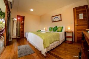 - une chambre avec un grand lit et des oreillers verts dans l'établissement Pousada Tímia, à Morro de São Paulo