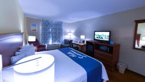 a hotel room with a bed and a flat screen tv at Days Inn by Wyndham Greensboro NC in Greensboro