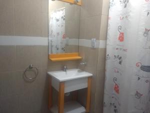 a bathroom with a sink and a shower curtain at Hotel Sahara in Villa Gesell