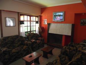a living room with two couches and a fireplace at Hotel Sahara in Villa Gesell