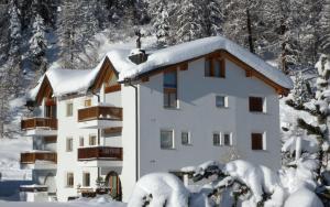 un edificio cubierto de nieve con árboles nevados en Sur Crasta, en Celerina