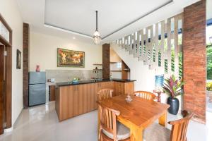 Il comprend une cuisine et une salle à manger avec une table et des chaises en bois. dans l'établissement Liam Private Villa, à Ubud