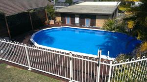 a swimming pool with a fence around it at Kincumber House in Kincumber