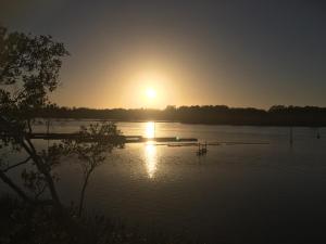 a sunset view of a lake with a sunset at Riverside Rest Nambucca Heads in Nambucca Heads