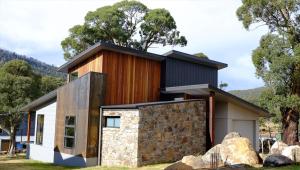 a contemporary house with a stone wall at Lake Crackenback Resort & Spa in Crackenback