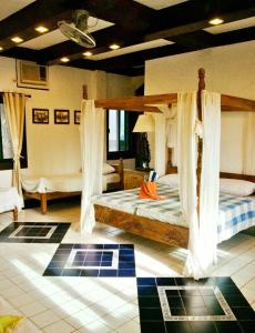 um quarto com 2 camas e cortinas em M Villa’s Farm Resort em Romblon