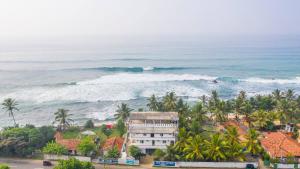 una vista aerea sull'oceano e su un edificio di Jayanthi Surf Dreams a Midigama East