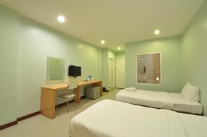 a bedroom with two beds and a desk and a television at The1place in Khon Kaen
