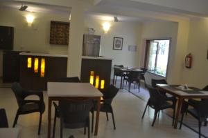 a restaurant with tables and chairs in a room at The Majorda Pristinne in Majorda