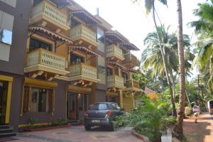 a car parked in front of a yellow building at The Majorda Pristinne in Majorda