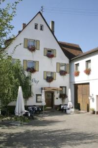 a large white building with tables and umbrellas in front of it at Spessarter Hof in Hobbach