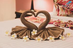 two swans made out of towels on a bed at Aukotan Place in Koh Tao