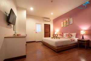 a bedroom with a bed and a flat screen tv at Aukotan Place in Koh Tao