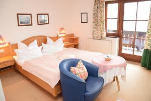 sypialnia z łóżkiem i niebieskim krzesłem w obiekcie Seehotel Huber w mieście St. Gilgen