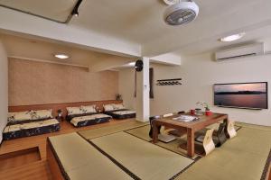 a living room with a table and a couch at 幸福滿屋 台南6人至40人包棟包層民宿 中西區花園 夜市附近住宿3分鐘 in Tainan