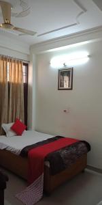 a bedroom with a bed with a red blanket at Paradise Villa in Vrindāvan