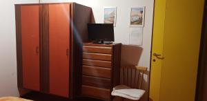 ein Schlafzimmer mit einer Kommode mit einem Fernseher drauf in der Unterkunft Villa Borca di Cadore in Borca di Cadore