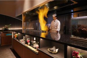 a chef standing in a kitchen with a fire at Hanashibuki in Tateyama