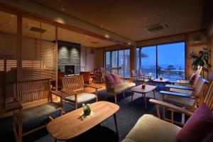 a restaurant with tables and chairs and a fireplace at Hanashibuki in Tateyama