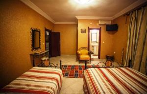 a hotel room with two beds and a mirror at Hotel Salama STE SAL- AMA SUD SARL AU in Tafraoute