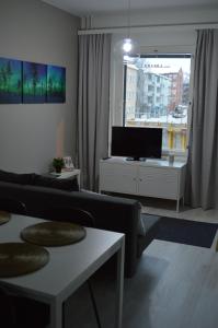 a living room with a couch and a flat screen tv at Aurora Haven Rovaniemi Modern DT Apartment -Self Check-In & Free Wifi- in Rovaniemi