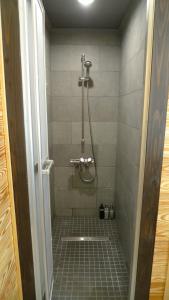a bathroom with a shower with a tiled floor at Ryder's House with FREE use of 4wd car in Hakuba
