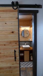 a bathroom with a sink and a mirror on a wooden wall at Ryder's House with FREE use of 4wd car in Hakuba
