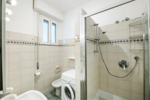 a bathroom with a shower and a toilet and a sink at Finalmarina Centro 2 in Finale Ligure +14 photos