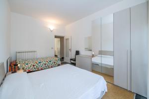 a white bedroom with a bed and a dresser at Finalmarina Centro 2 in Finale Ligure