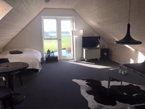 a bedroom with a bed and a large window at Holmens Guesthouse in Lemming