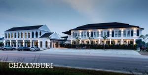 un grand bâtiment blanc avec une rue en face dans l'établissement Chaanburi Boutique Resort, à Chanthaburi