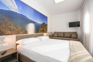 1 dormitorio con 1 cama grande y una pintura en la pared en Residence Franca B&B, en Arco