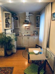 uma cozinha com uma mesa de vidro e uma mesa; em Lovely Studio in the Heart of the City em Vinnytsya