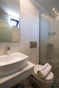 a bathroom with a sink and a toilet and a shower at Kordistos Hotel in Kefalos