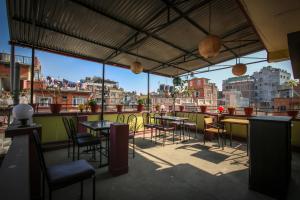 a patio with tables and chairs and a view of the city at Peace Home in Kathmandu