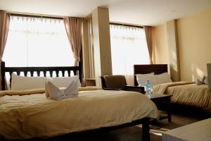 a hotel room with two beds and a table at Peace Home in Kathmandu