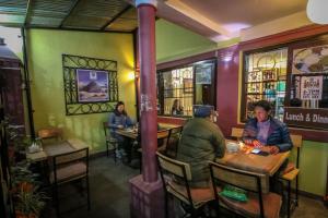 a group of people sitting at tables in a restaurant at Peace Home in Kathmandu