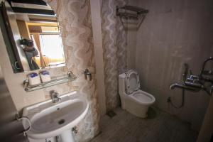 a person taking a picture of a bathroom with a sink and toilet at Peace Home in Kathmandu